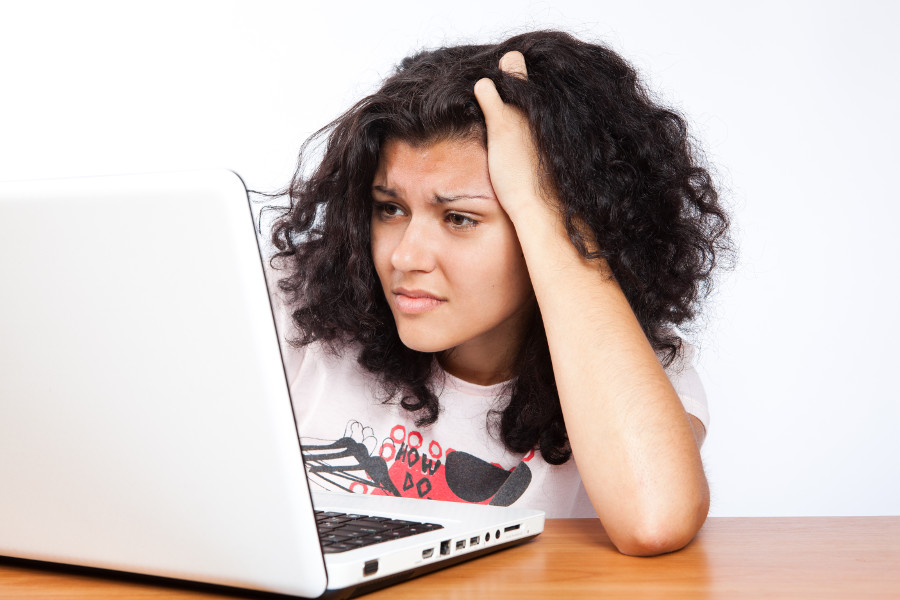 A frustrated woman looking at her laptop